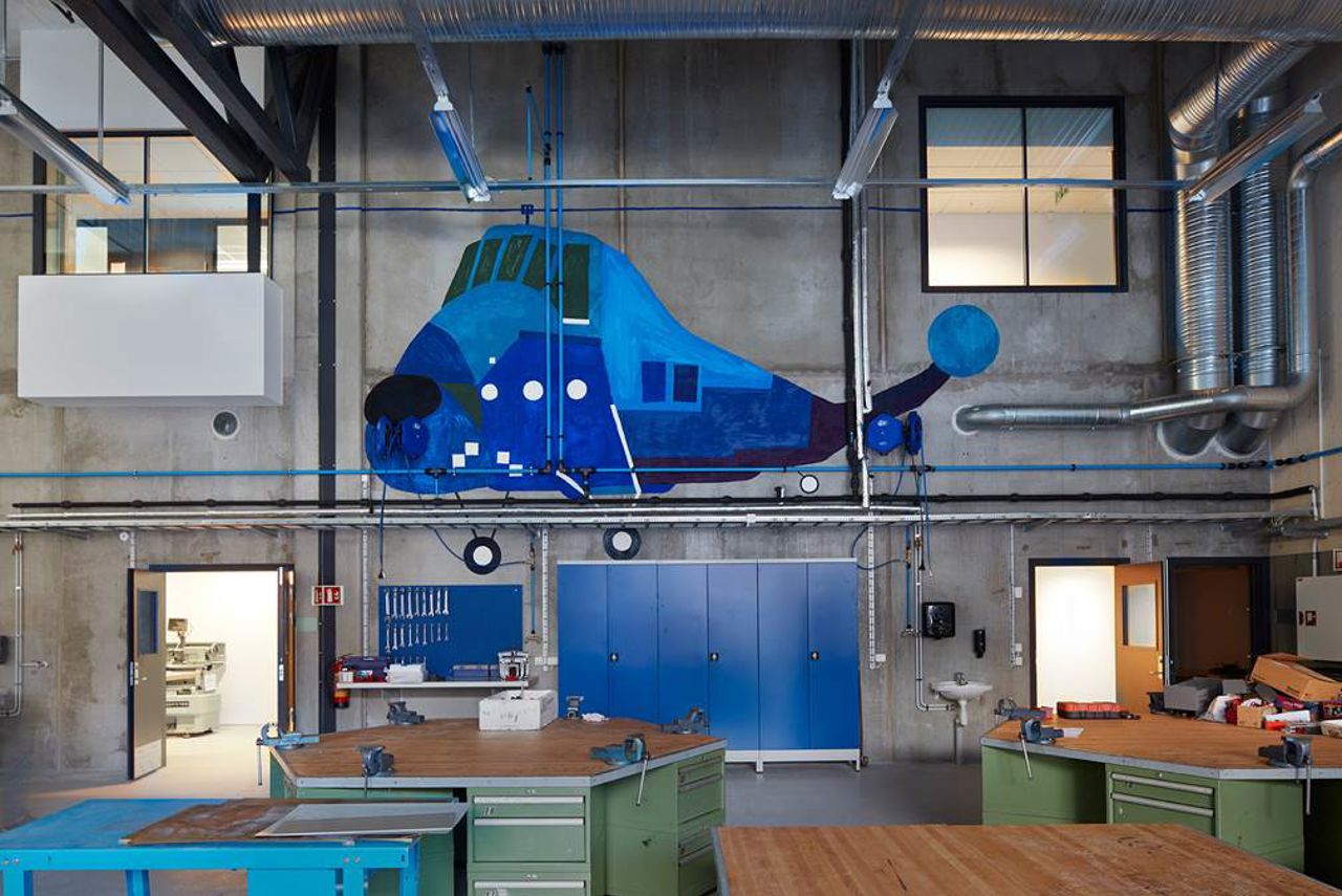 Kunst på verkstadveggen, eit blått helikopter.