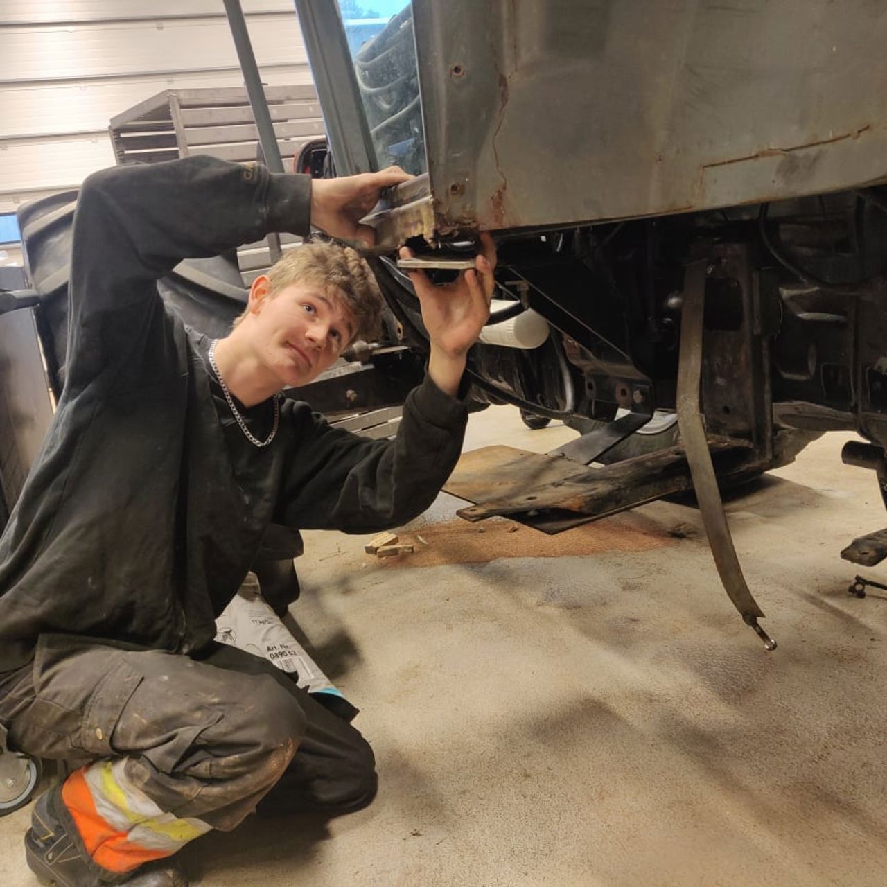 Elev i arbeid på verkstaden til arbeidsmaskin.