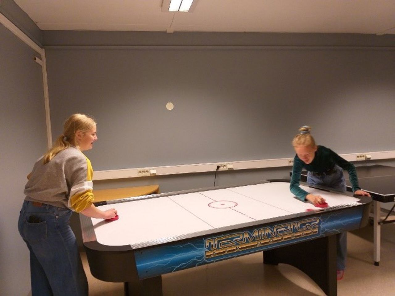 Elevar som spelar shuffleboard på internatet.